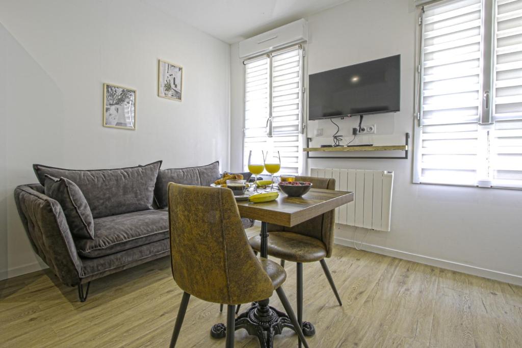un salon avec une table et un canapé dans l'établissement F2 hypercentre - Proche gare - WIFI gratuite, au Havre