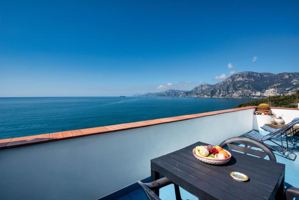 a bowl of fruit sitting on a table on a balcony at Casa Rosamare, 150 stairs from the road by Wonder Tour in Praiano