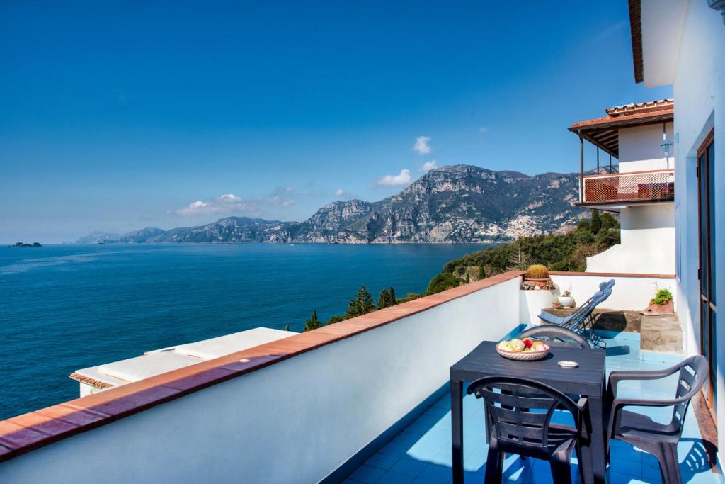 balcón con mesa y sillas y vistas al agua en Casa Rosamare en Praiano