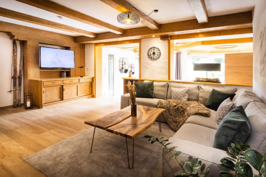 sala de estar con sofá y TV en Ferienresidenz "Alpin Chic", en Bolsterlang
