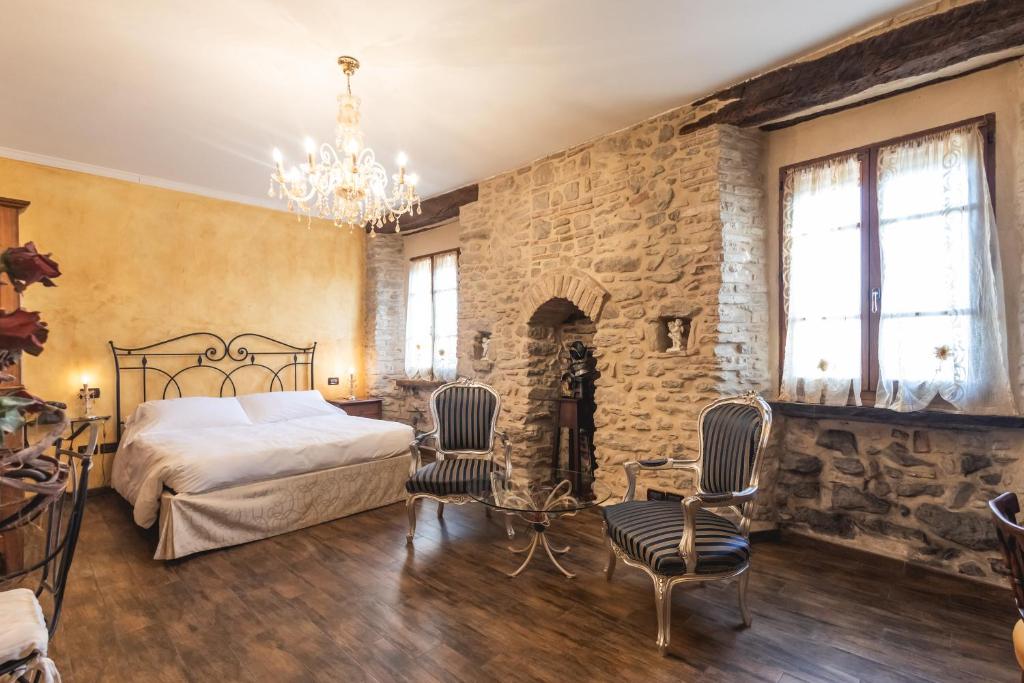 1 dormitorio con cama y pared de piedra en Locanda dell'Ambra - Eleganza Rustica nel cuore della Romagna, en Talamello