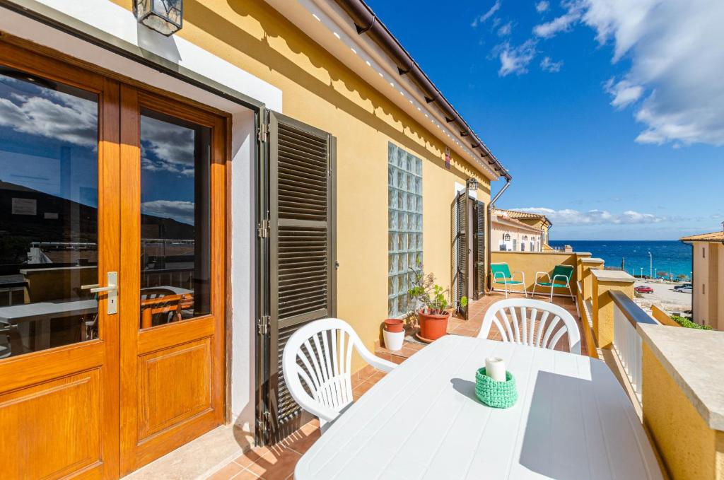 un tavolo bianco e sedie su un balcone con vista sull'oceano di YourHouse Sol i Mar 2 beach apartment a Cala Mesquida