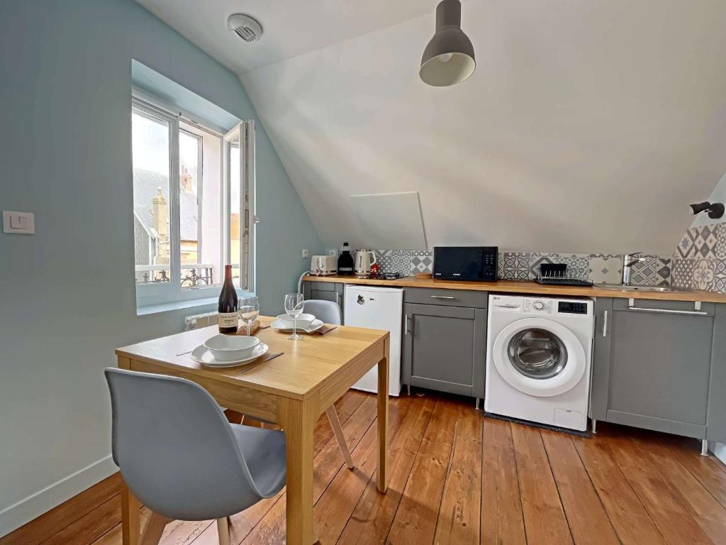 une cuisine avec une table et une machine à laver dans l'établissement Studio rénové cœur centre-ville, tout confort avec wifi, TV et lave-linge, proche commerces - Berck - FR-1-646-15, à Berck-sur-Mer