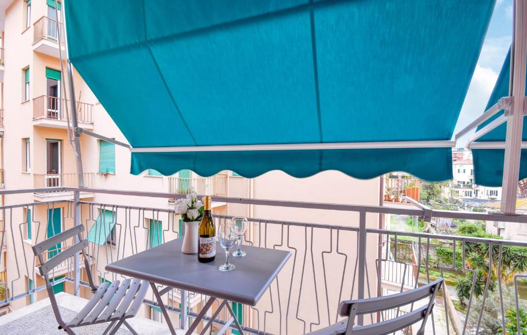 a table and chairs on a balcony with a blue umbrella at 2 Bedroom Awesome Apartment In Chiavari in Chiavari