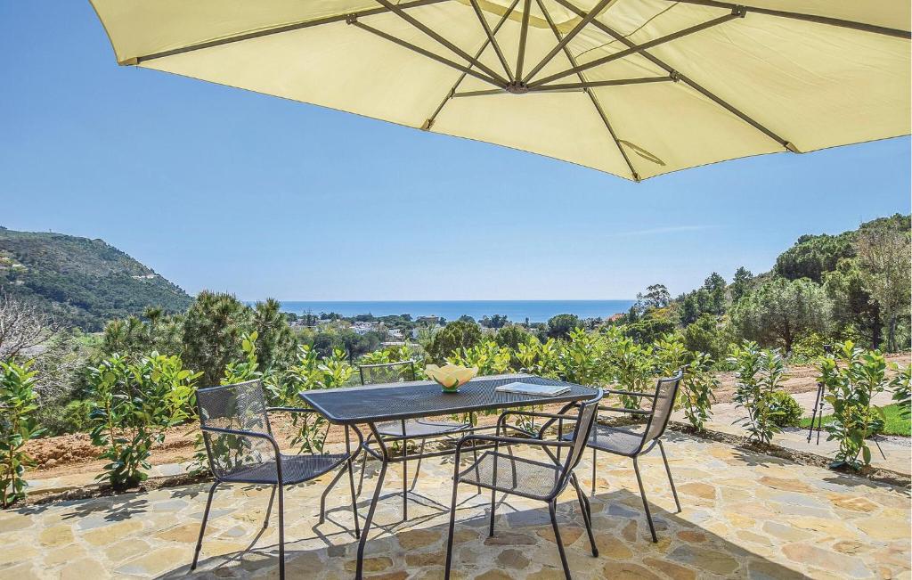 - une table et des chaises sur une terrasse avec un parasol dans l'établissement Awesome Apartment In Ogliastro Marina With Wifi, à Castellabate