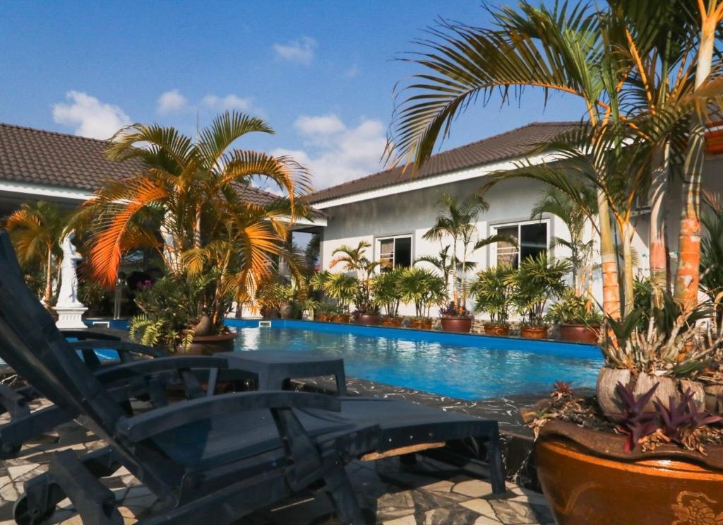 una piscina frente a una casa con palmeras en MB House Resort, en Ban Nai Rai