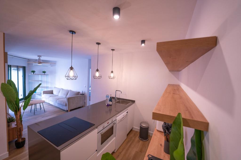 a kitchen and living room with a couch and a table at Apartasuites Royal Zahara, Máximo confort con vistas al mar in Zahara de los Atunes