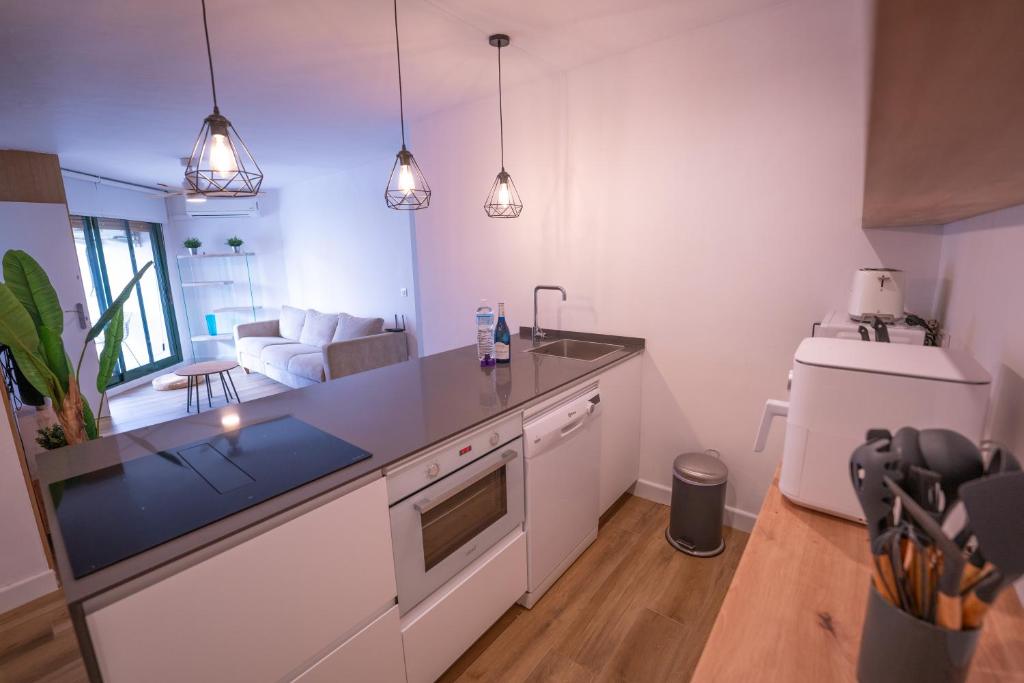 a kitchen with a counter top and a living room at Apartasuites Royal Zahara, Máximo confort con vistas al mar in Zahara de los Atunes