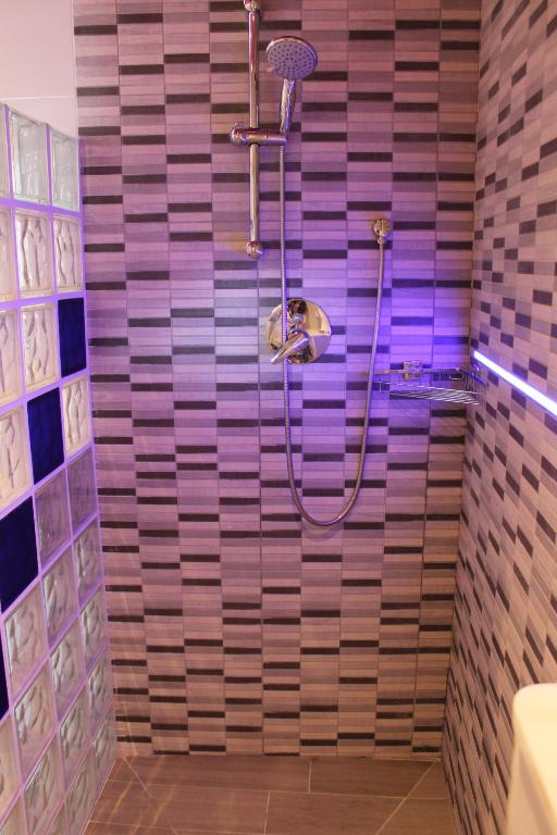 a bathroom with a shower with purple tiles at Apartamentos turísticos Vistademar in Luarca