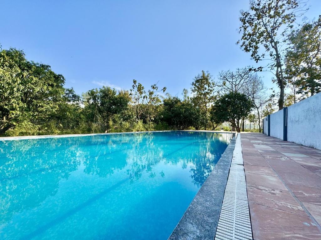 una imagen de una piscina en una casa en The White Oak Corbett Spa & Resort en Rāmnagar