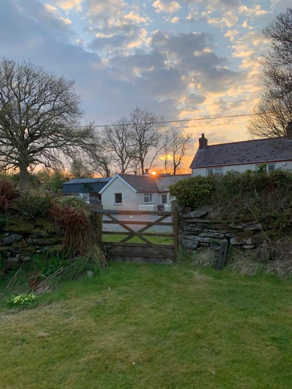 a fence in front of a house and a house at Newfoundland Cottage in Whitechurch