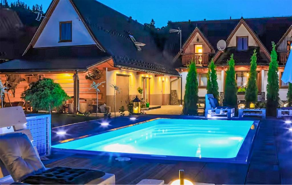 a swimming pool in the backyard of a house at night at Gorgeous Home In Poronin With Wi-fi in Poronin