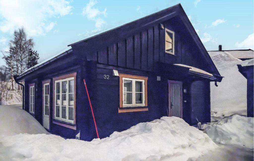 une petite maison bleue avec de la neige autour de celle-ci dans l'établissement Nice Home In Kongsberg With Kitchen, à Kongsberg