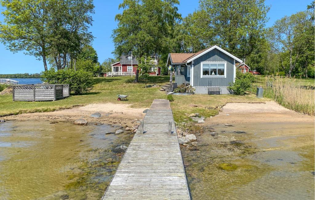 ein Haus am Ufer eines Flusses mit einem Dock in der Unterkunft 2 Bedroom Nice Home In Norrtlje in Norrtälje
