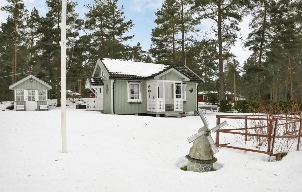 ein kleines Haus mit einer Windmühle im Schnee in der Unterkunft Cozy Home In Väse With Wifi in Väse