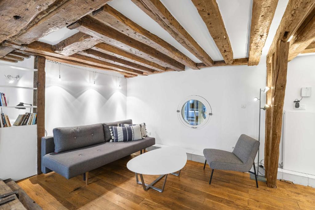 a living room with a couch and a table at Caprice Amour in Paris