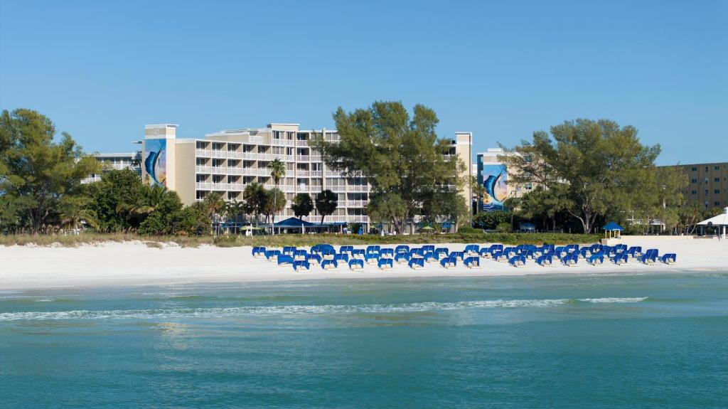 um grupo de cadeiras azuis na praia em RumFish Beach Resort by TradeWinds em St Pete Beach