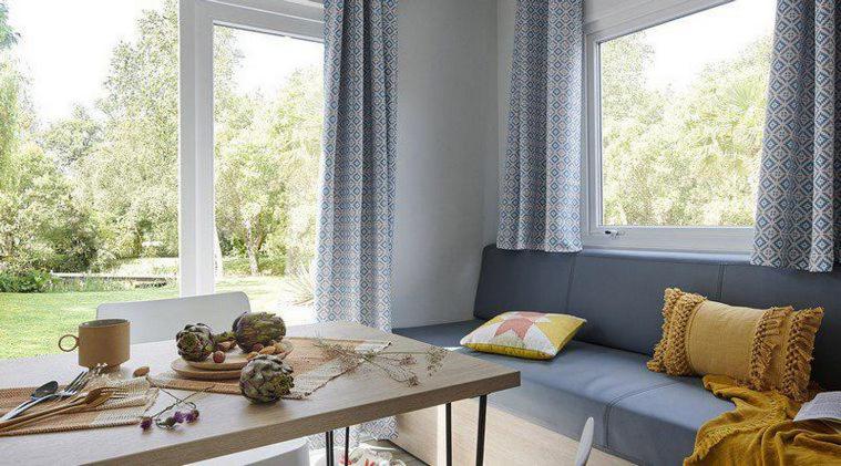 - un salon avec un canapé bleu et une table dans l&#39;établissement Camping de Keranterec, à La Forêt-Fouesnant