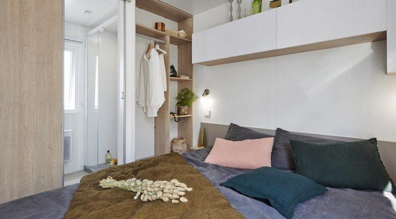 - une chambre avec un grand lit orné de fleurs dans l&#39;établissement Camping de Keranterec, à La Forêt-Fouesnant