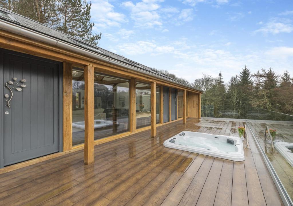 una casa con bañera de hidromasaje en una terraza de madera en River View Lodge, en Allendale