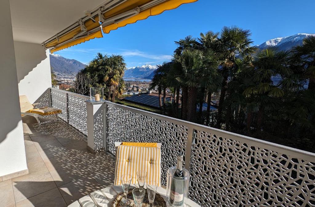 a balcony with a table and chairs and mountains at Ascona Bellavista in Ascona