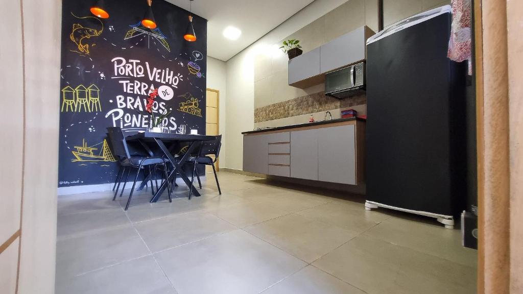eine Küche mit einem Tisch und Stühlen sowie einem Kühlschrank in der Unterkunft Achei Casa 6: Seu espaço exclusivo em Porto Velho in Porto Velho