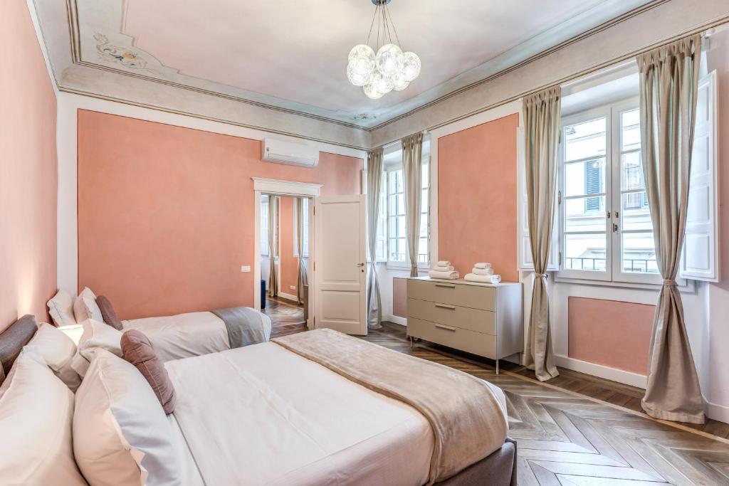 Duas camas num quarto com paredes e janelas cor-de-rosa em La Rosa em Florença