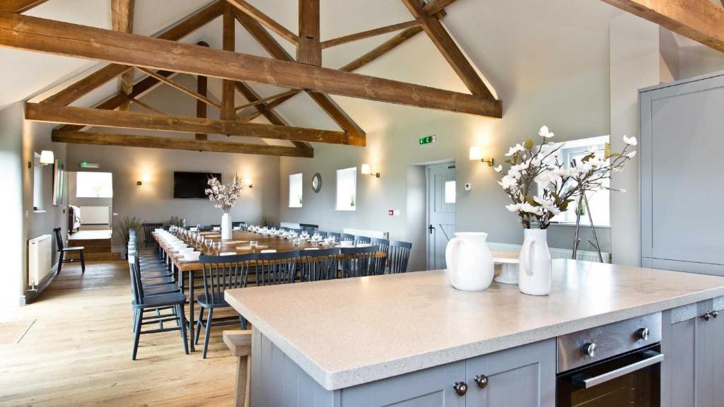 cocina y comedor con mesas y sillas en Manifold Barns en Belper