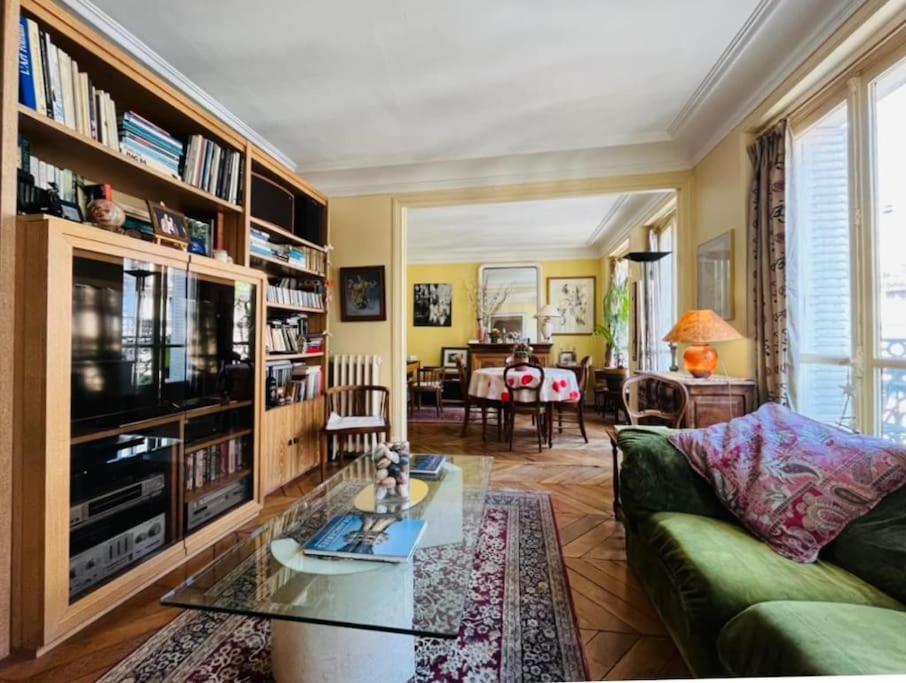 un salon avec un canapé vert et une table dans l'établissement Excellence YourHostHelper, à Paris