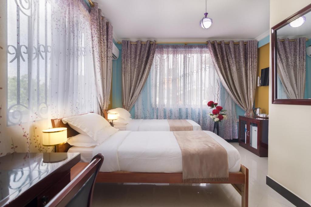 um quarto de hotel com uma cama e uma janela em New Mazubu Grand Hotel Mererani em Mbuguni