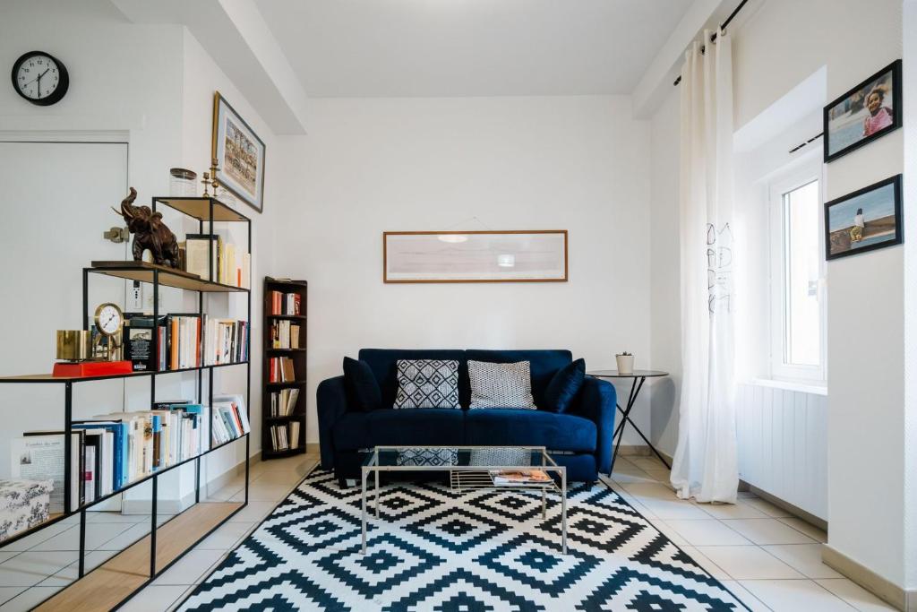 a living room with a blue couch and a book shelf at Calm & Comfort / Near Part-Dieu AIL in Lyon