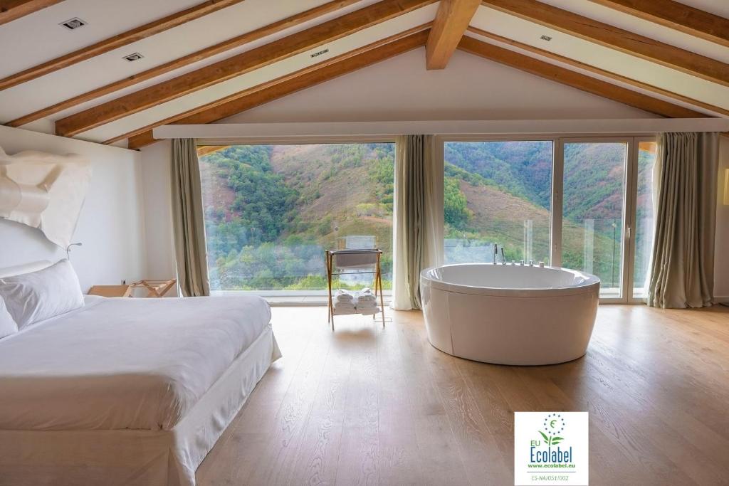 a bedroom with a large bed and a bath tub at Arantza Hotela- Adults Only in Arantza