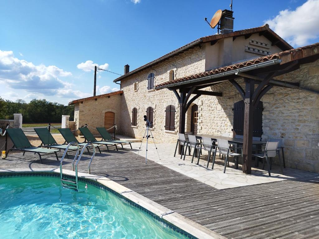 uma casa com piscina, mesa e cadeiras em Gîte avec piscine Chez Labaurie em Marthon