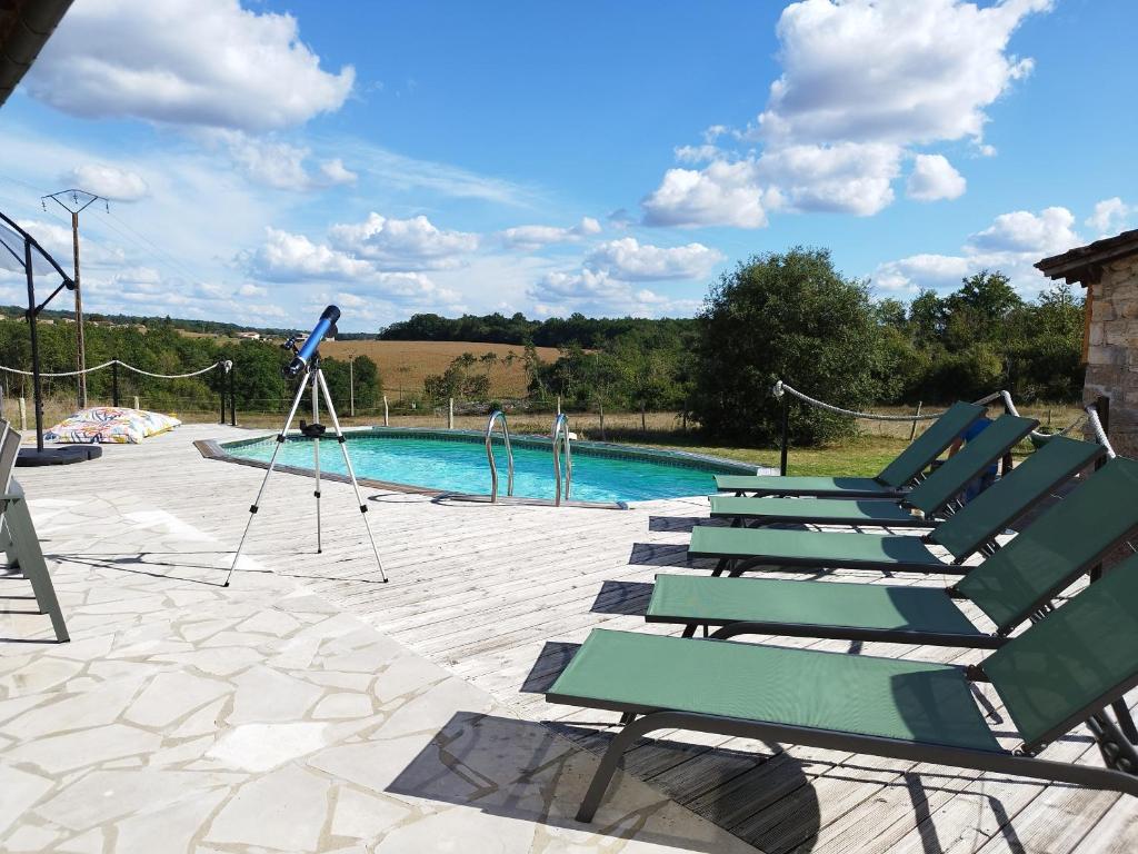 a group of chairs sitting next to a swimming pool at Gîte avec piscine Chez Labaurie in Marthon