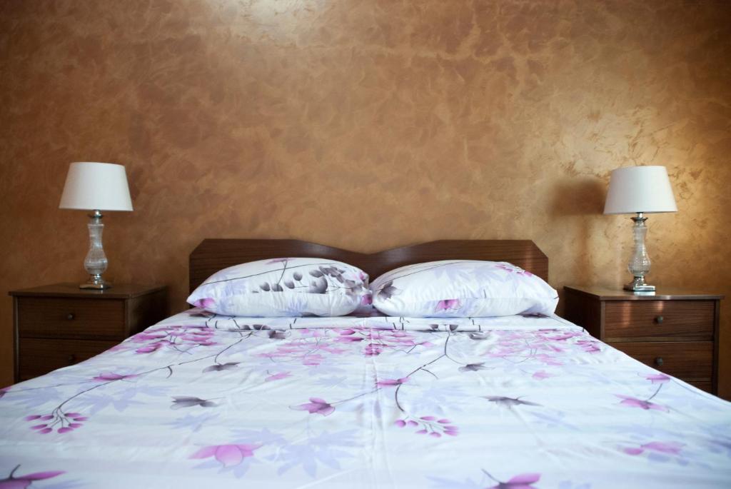 a bed with two pillows and two lamps at Gaia garden house in Gáïa