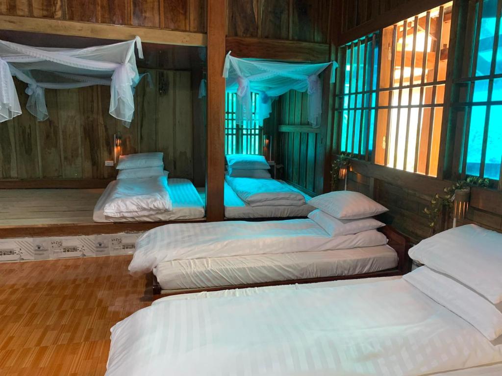 a group of four beds in a room at Homestay Chân Núi in Sa Pả