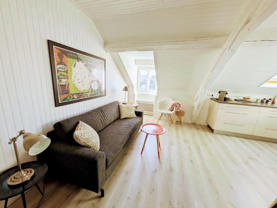 un salon avec un canapé et une table dans l'établissement Foch, vue mer, cœur de ville, à Pornic