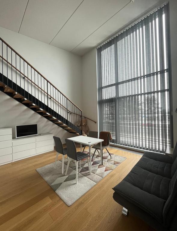 a living room with a table and chairs at Spacious loft apartment with a lake view in Tampere