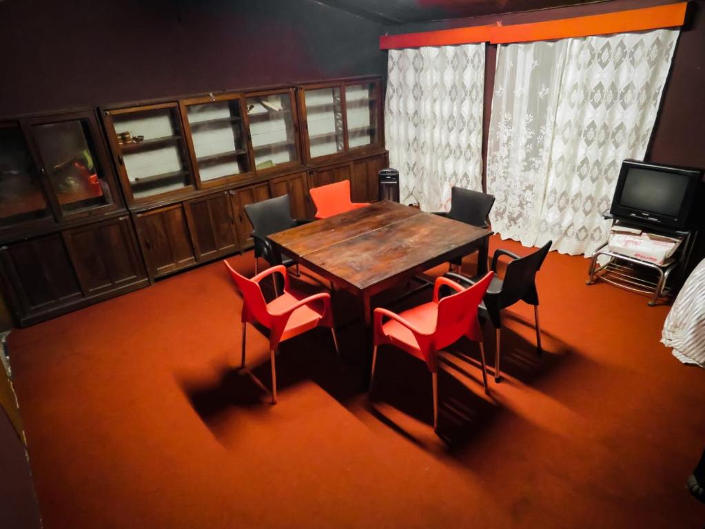 a dining room with a wooden table and chairs at Woodside Bungalow1 in Ooty