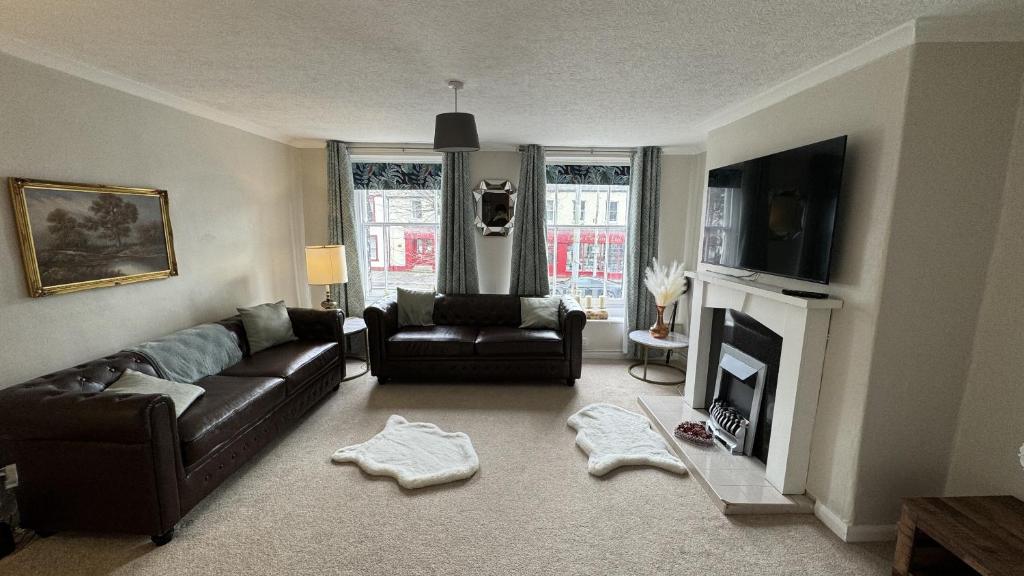 a living room with a couch and a fireplace at Hummingbird House in Cockermouth