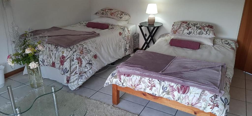 a bedroom with two beds and a vase of flowers at Biedouw Padstal & Toerisme in Clanwilliam