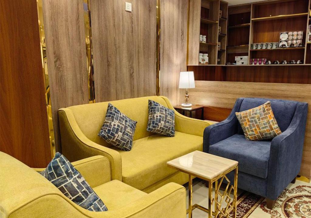 Zad al Bait Hotel في مكة المكرمة: غرفة معيشة مع أريكة صفراء وكرسي أزرق
