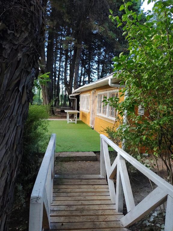 una casa con una escalera de madera que conduce a un patio en Mi refugio arbolado, en Cabrero