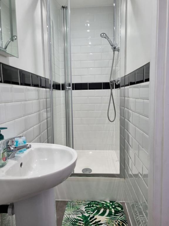 a white bathroom with a shower and a sink at The Windmill Hotel in London