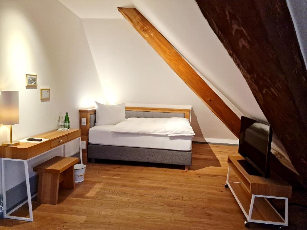 a bedroom with a bed and a desk and a television at Hotel Weissenstein in Oberdorf