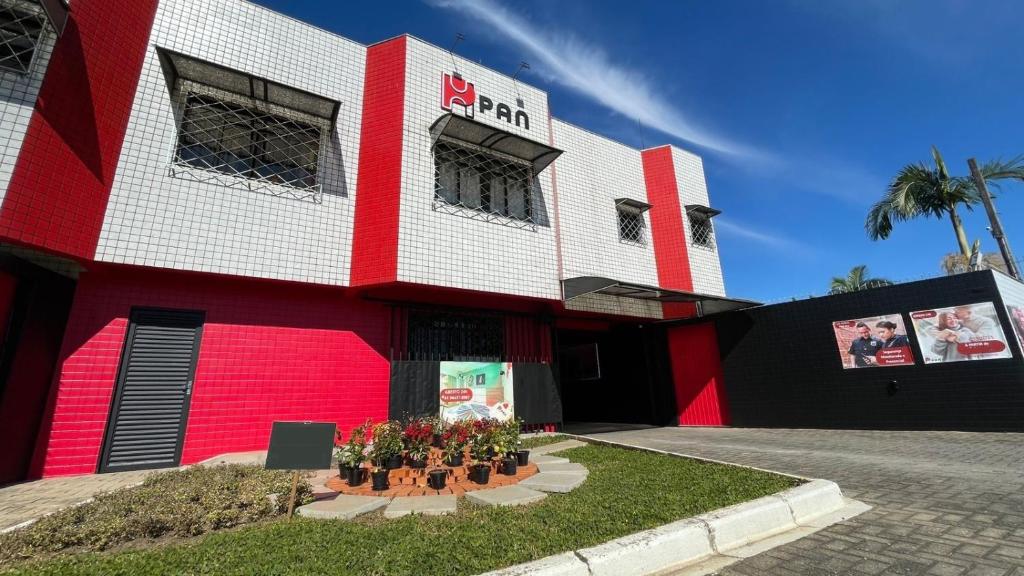 un edificio rojo y blanco con flores delante en Pan HM, en Curitiba