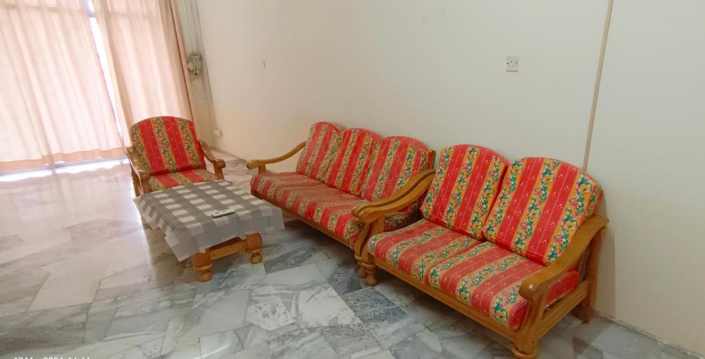 ein Wohnzimmer mit 2 Stühlen und einem Tisch in der Unterkunft Pilah homestay in Kuala Pilah