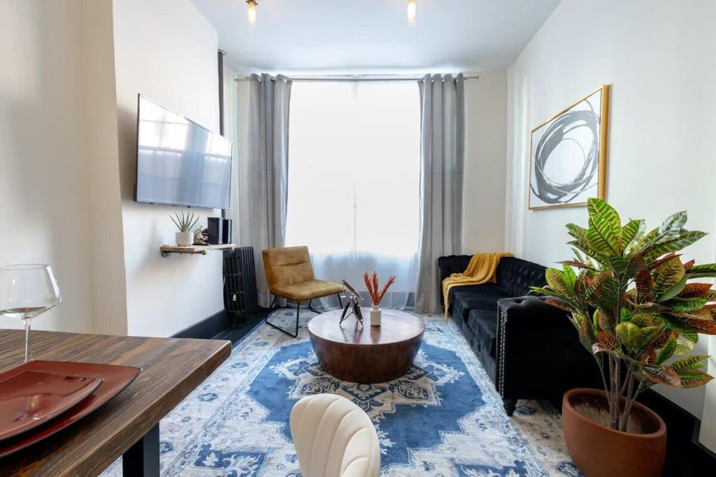 a living room with a couch and a table at E10-1 Designer East Village Townhouse 1BR in New York