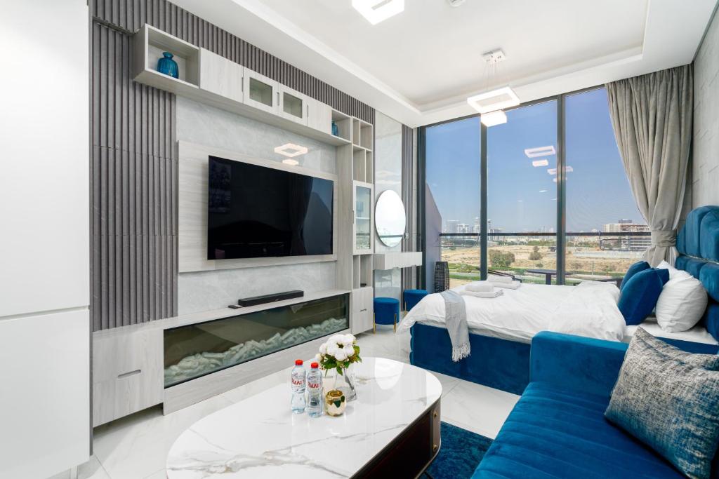 a living room with a blue couch and a tv at TAMM HOMES-SAMANA GOLF AVENUE in Dubai