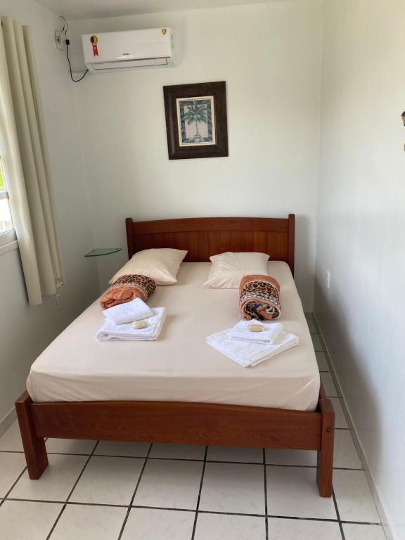 uma cama num quarto com duas toalhas em Casa geminada 1 em Florianópolis